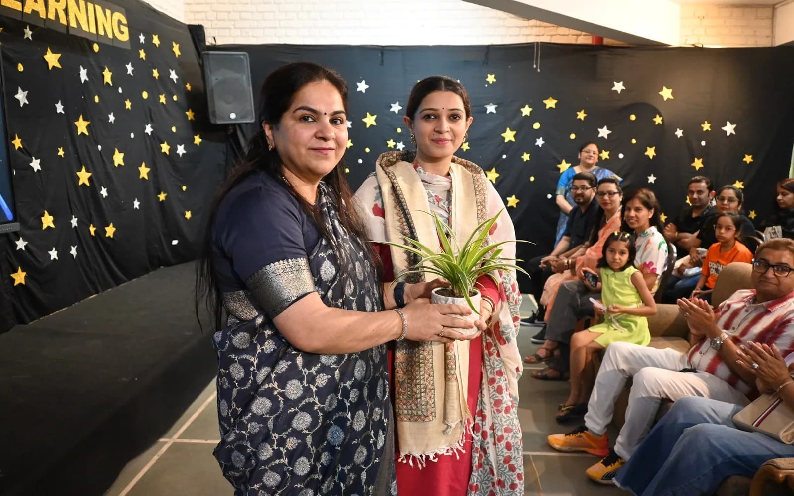 An alumna being welcomed back at a Salwan community gathering