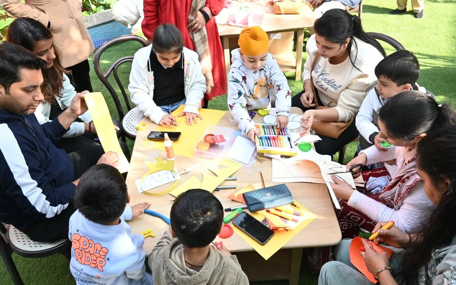 Parents and children creating artwork together at a school event
